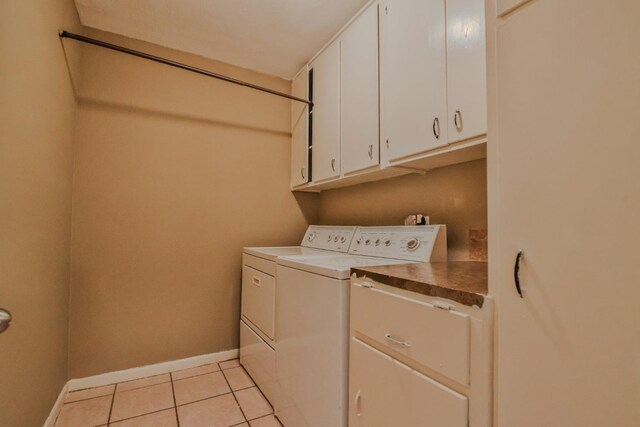 clothes washing area featuring cabinets, separate washer and dryer, and light tile patterned floors