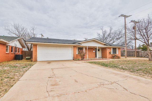 ranch-style home featuring cooling unit and a garage