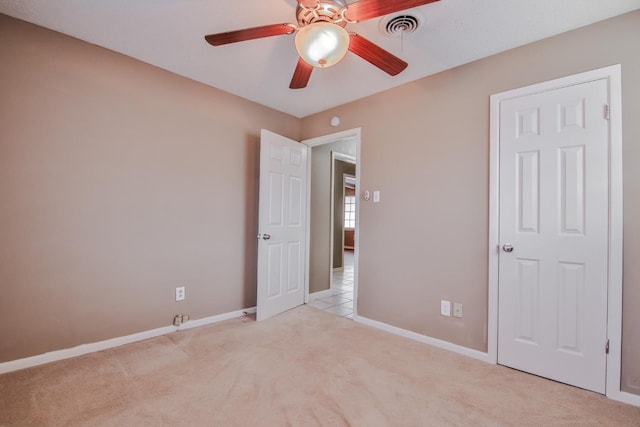 unfurnished bedroom featuring ceiling fan and light colored carpet