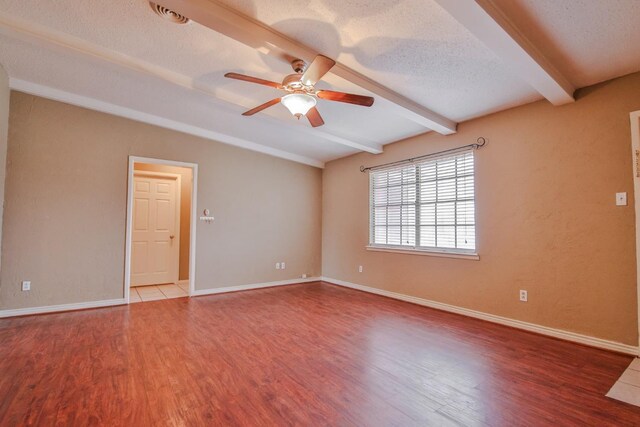 unfurnished room with ceiling fan, a textured ceiling, beamed ceiling, and hardwood / wood-style flooring