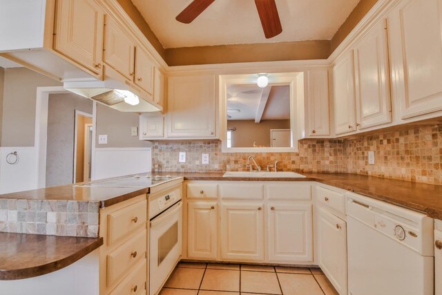 kitchen with light tile patterned flooring, sink, tasteful backsplash, kitchen peninsula, and white appliances