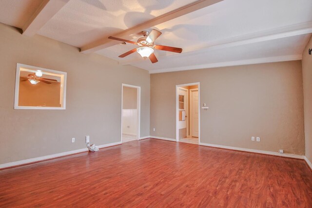 empty room featuring ceiling fan, beam ceiling, and hardwood / wood-style floors