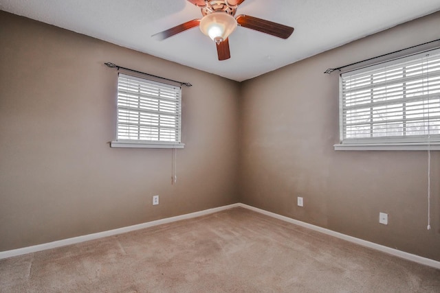 unfurnished room featuring ceiling fan, light colored carpet, and a healthy amount of sunlight