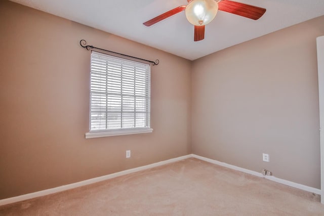 carpeted spare room featuring ceiling fan