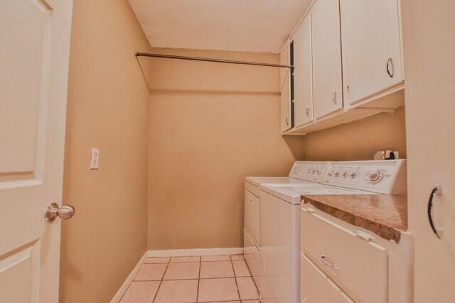 laundry room with cabinets, separate washer and dryer, and light tile patterned floors