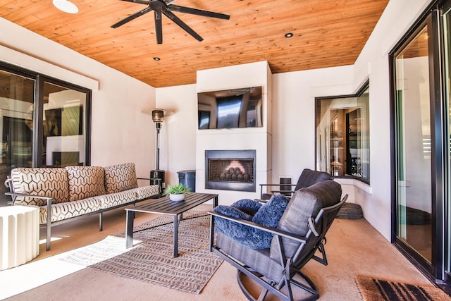 living room featuring ceiling fan, a fireplace, and wooden ceiling