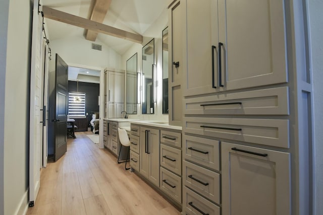 bathroom featuring hardwood / wood-style flooring, vanity, and vaulted ceiling with beams