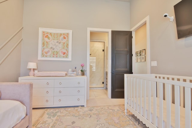 bedroom featuring ensuite bath and a crib