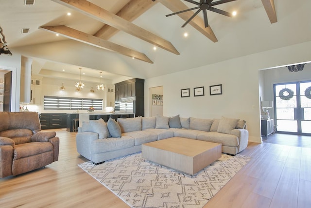 living room featuring an inviting chandelier, beam ceiling, high vaulted ceiling, and light hardwood / wood-style flooring