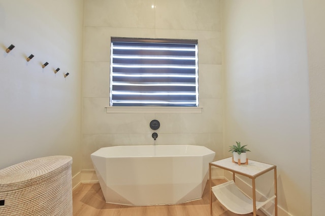 bathroom with wood-type flooring and a tub