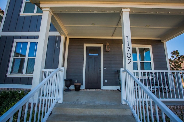 view of exterior entry featuring covered porch