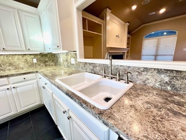 kitchen featuring white cabinetry and sink