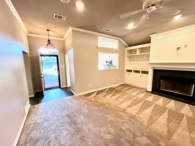 unfurnished living room featuring ornamental molding, dark carpet, and a textured ceiling