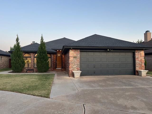 view of front facade with a garage and a yard