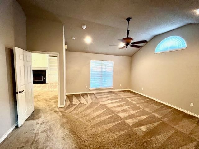 spare room with ceiling fan, carpet floors, and vaulted ceiling