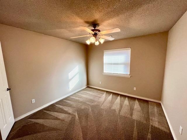 carpeted spare room featuring a textured ceiling and ceiling fan