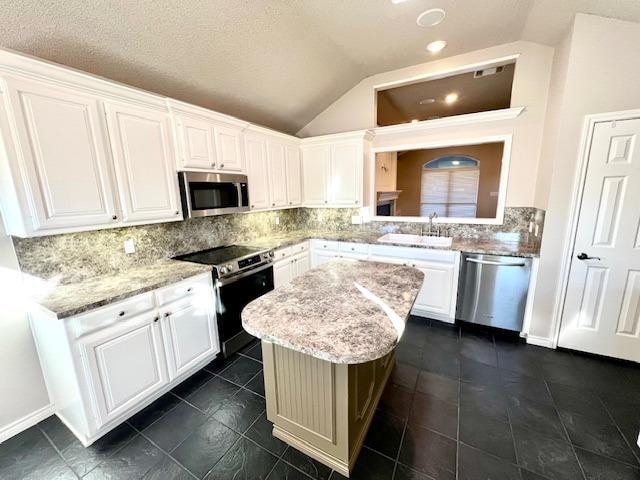 kitchen with a kitchen island, appliances with stainless steel finishes, and white cabinets