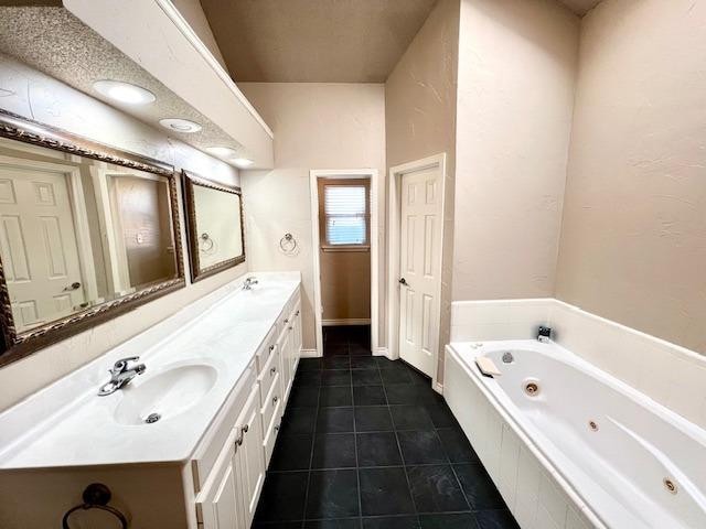 bathroom with vanity, a bath, and tile patterned floors