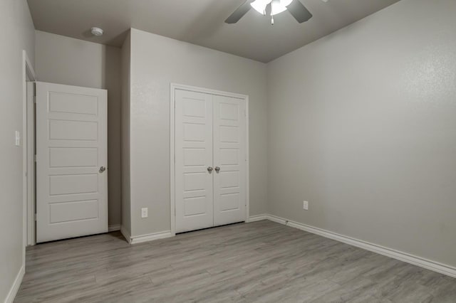 unfurnished bedroom featuring ceiling fan, a closet, and light hardwood / wood-style flooring