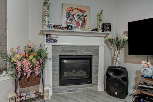 room details with hardwood / wood-style floors and a stone fireplace