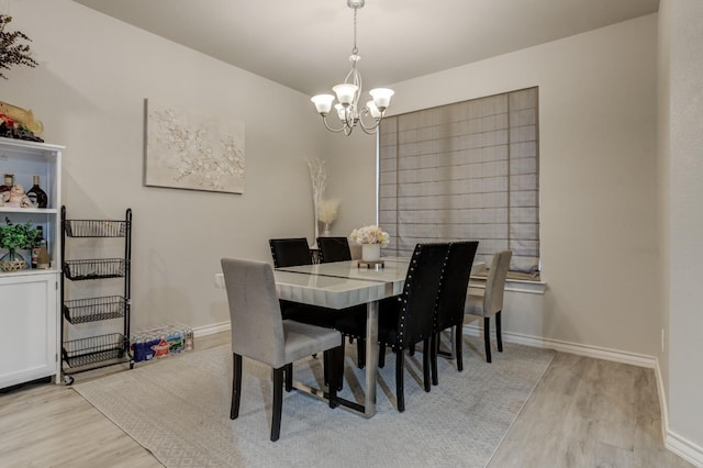 dining area featuring a notable chandelier and light hardwood / wood-style flooring