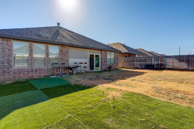 rear view of property featuring a yard