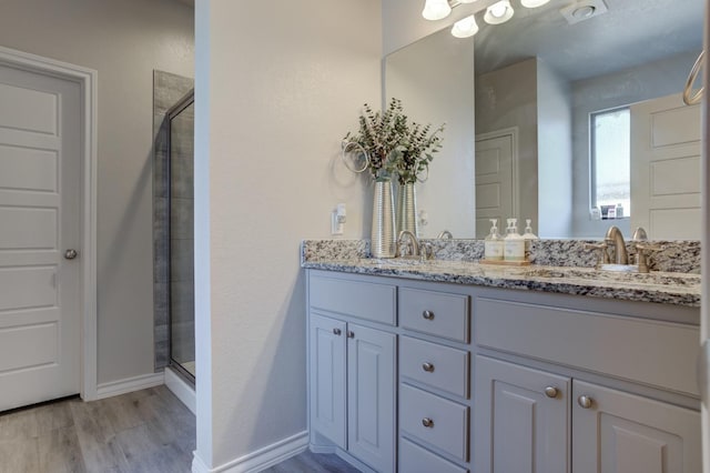 bathroom with vanity, hardwood / wood-style flooring, and walk in shower