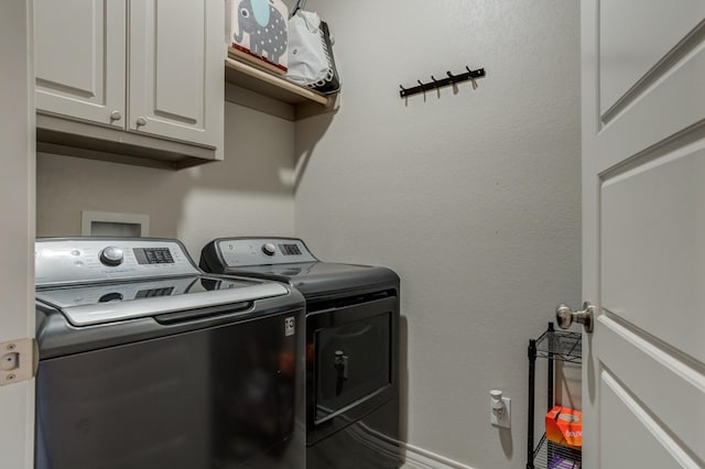 laundry area with cabinets and washing machine and clothes dryer