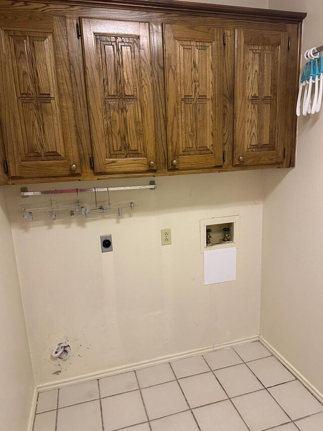 washroom with cabinets, washer hookup, hookup for an electric dryer, and light tile patterned floors