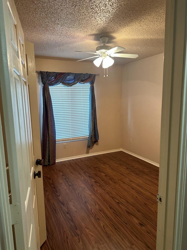 unfurnished room with ceiling fan, dark hardwood / wood-style floors, and a textured ceiling