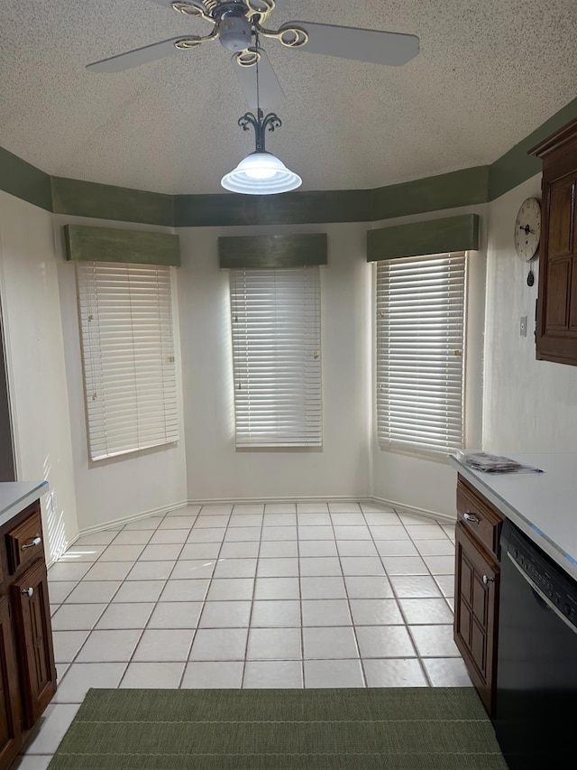 unfurnished dining area featuring light tile patterned floors, a textured ceiling, and ceiling fan