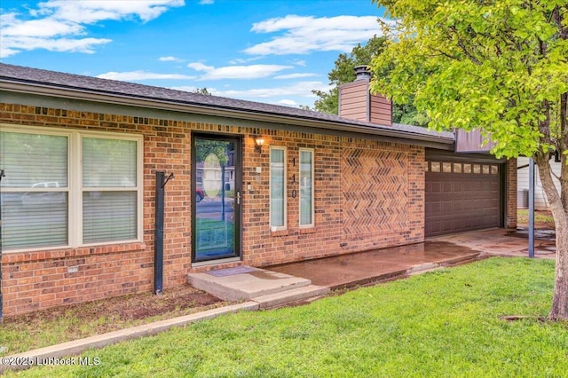 110 E 18th St, Littlefield, TX 79339 - entrance to property with brick siding, a lawn, a chimney, and a garage