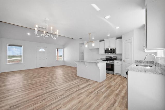 kitchen with sink, a center island, appliances with stainless steel finishes, light hardwood / wood-style floors, and white cabinets