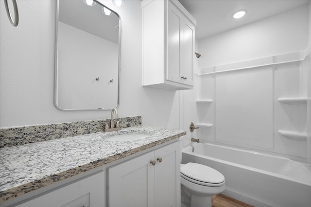 full bathroom featuring vanity, hardwood / wood-style flooring, tub / shower combination, and toilet