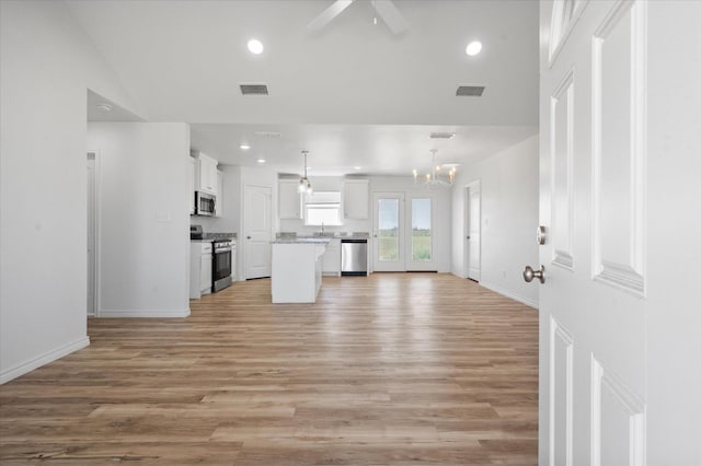 kitchen with hanging light fixtures, a center island, white cabinets, and appliances with stainless steel finishes