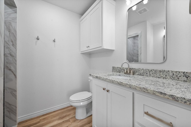 bathroom with hardwood / wood-style flooring, vanity, and toilet