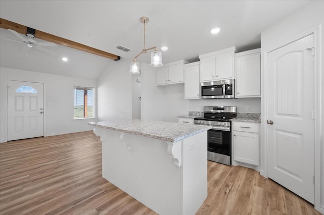 kitchen with pendant lighting, appliances with stainless steel finishes, a center island, and white cabinets