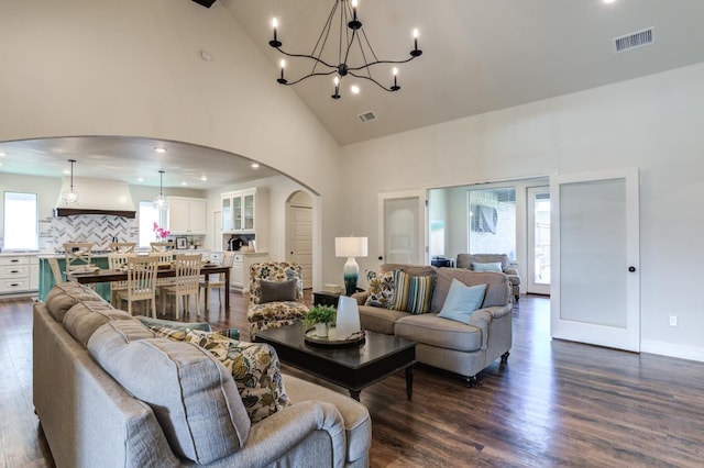 living room with hardwood / wood-style flooring, a chandelier, and high vaulted ceiling