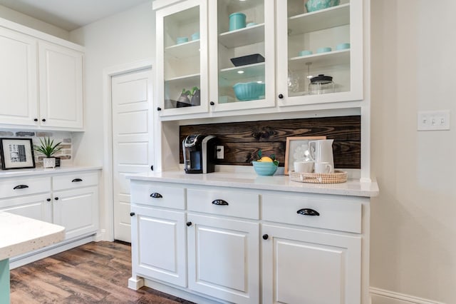 bar with white cabinetry, light stone countertops, and dark hardwood / wood-style floors