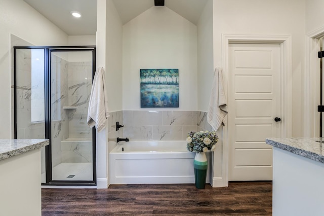 bathroom with hardwood / wood-style flooring, vanity, and plus walk in shower