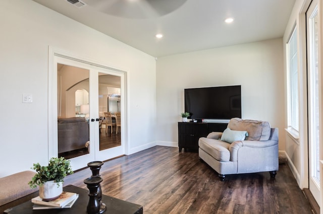 living area with ceiling fan and dark hardwood / wood-style floors