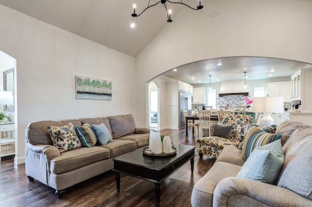 living room with high vaulted ceiling, dark hardwood / wood-style floors, and a chandelier