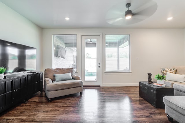 living room with dark hardwood / wood-style flooring and ceiling fan