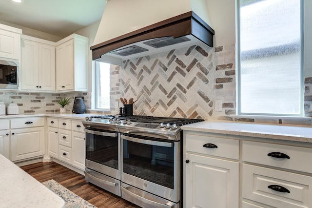 kitchen featuring stainless steel appliances, white cabinets, dark hardwood / wood-style flooring, decorative backsplash, and custom exhaust hood