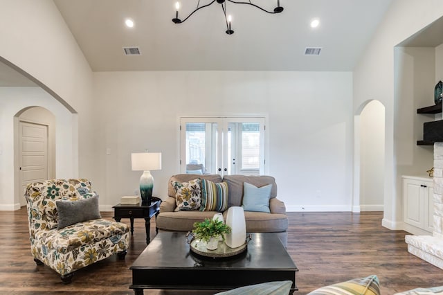 living room with french doors, dark hardwood / wood-style flooring, high vaulted ceiling, and a notable chandelier