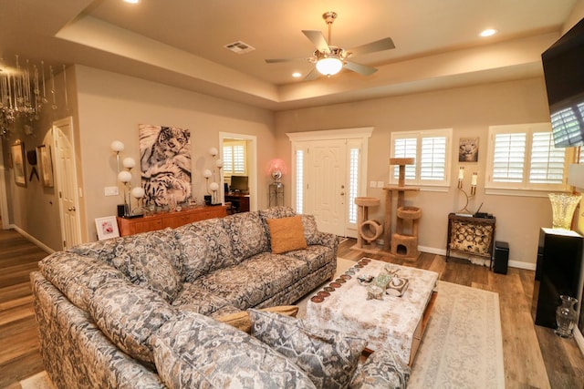 living room with ceiling fan, a raised ceiling, and hardwood / wood-style floors