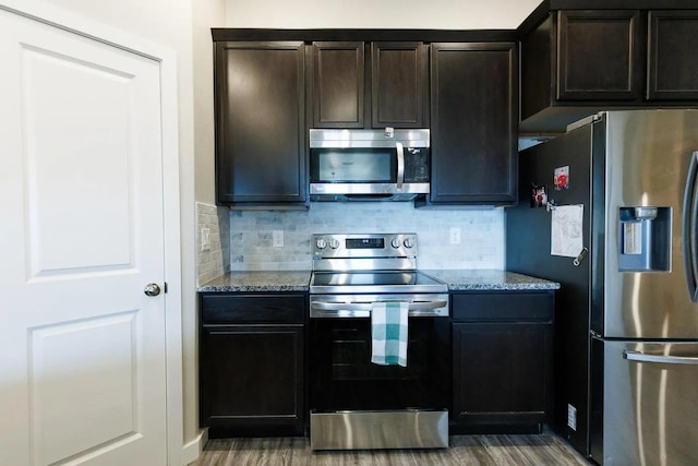 kitchen with light stone counters, backsplash, stainless steel appliances, and dark brown cabinetry