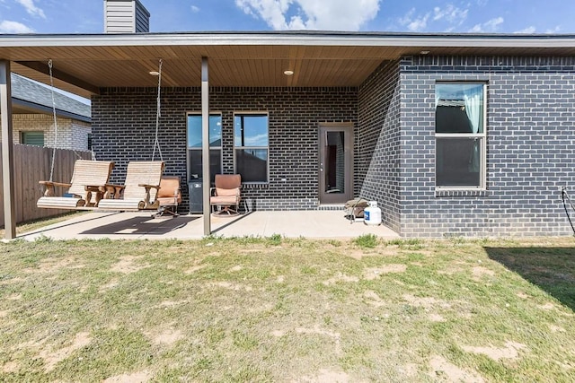 rear view of property featuring a patio and a yard