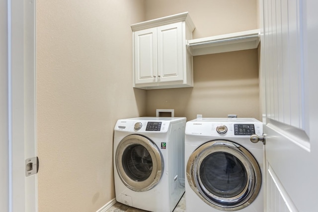 washroom with cabinets and washer and clothes dryer