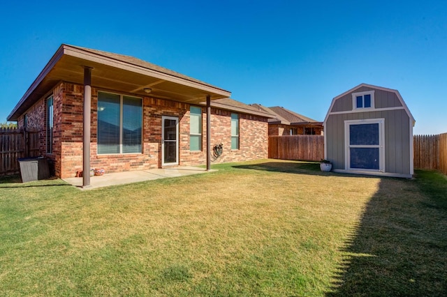 back of property with a shed, a yard, and a patio